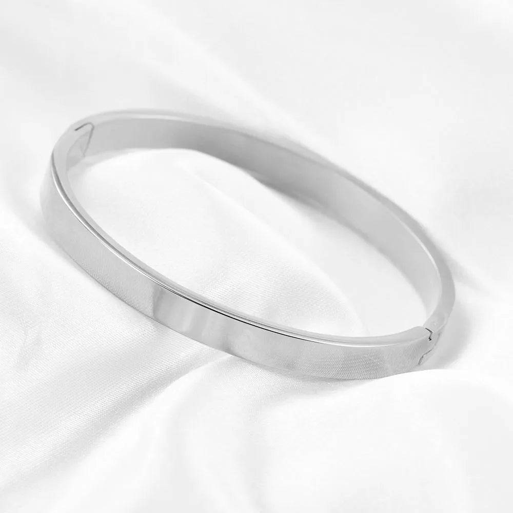 Stainless steel snap bracelet with polished finish in gold colour on a white background