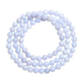 Close-up of a handmade blue agate bracelet with natural striped beads on a wrist.