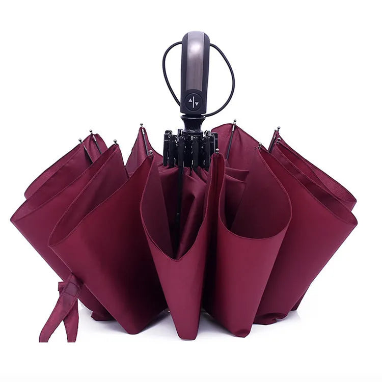 Black automatic open triple-folding business umbrella with a ribbed rubber handle, shown deployed.