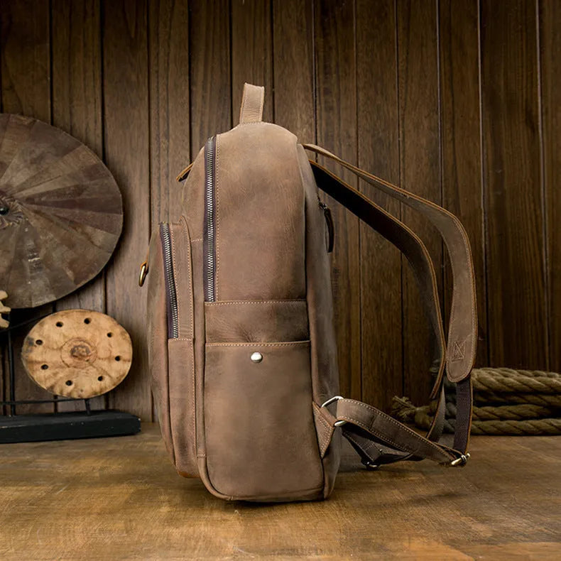 Retro brown leather backpack for men, 20L bucket shape with zipper, laptop pocket and phone pouch.