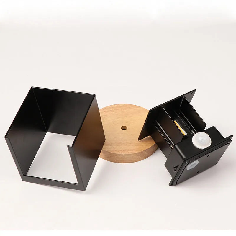 Square black aluminium alloy wall lamp mounted on a corridor wall
