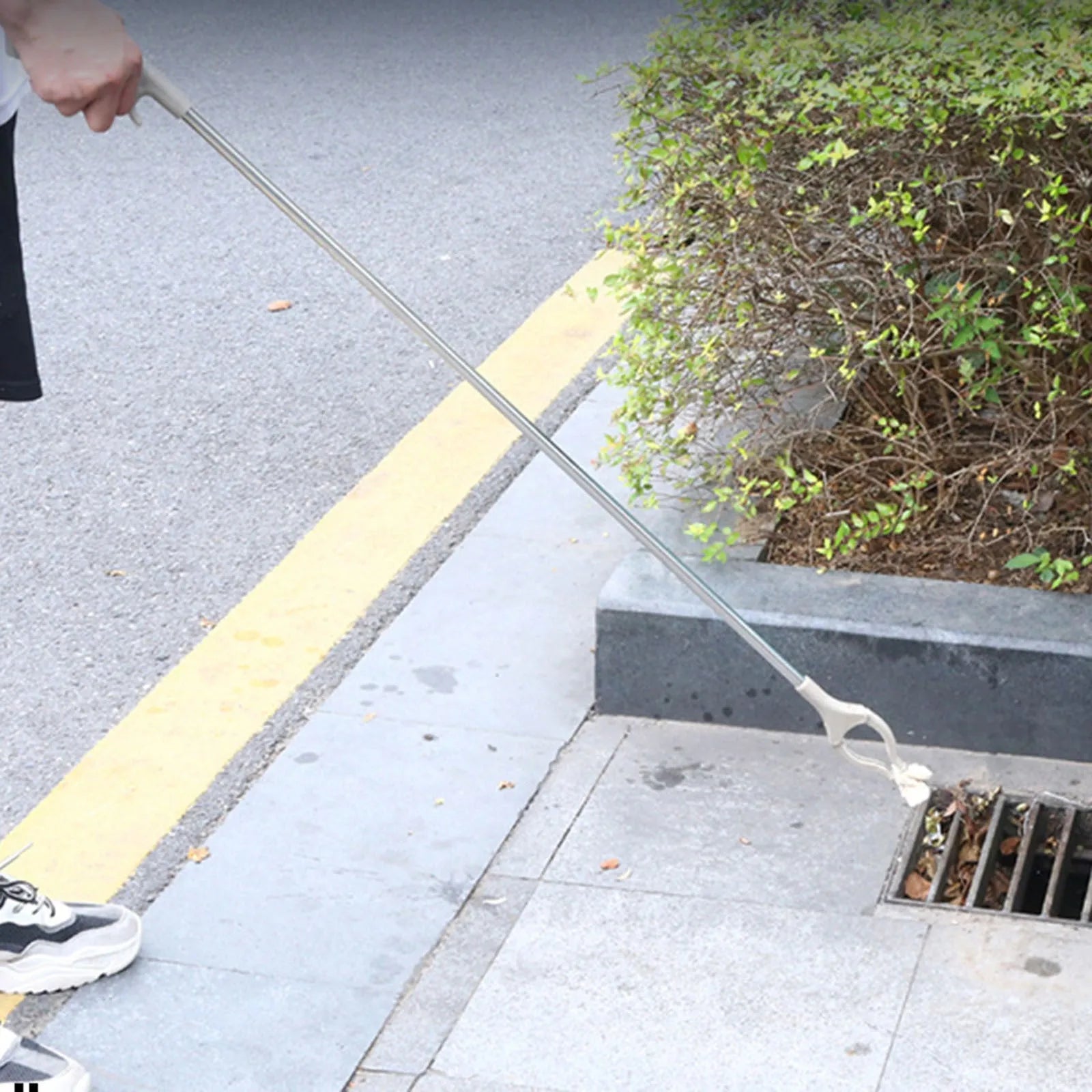 A 40 cm long stainless steel and plastic trash picker tool with a non-slip chuck and push-type handle.