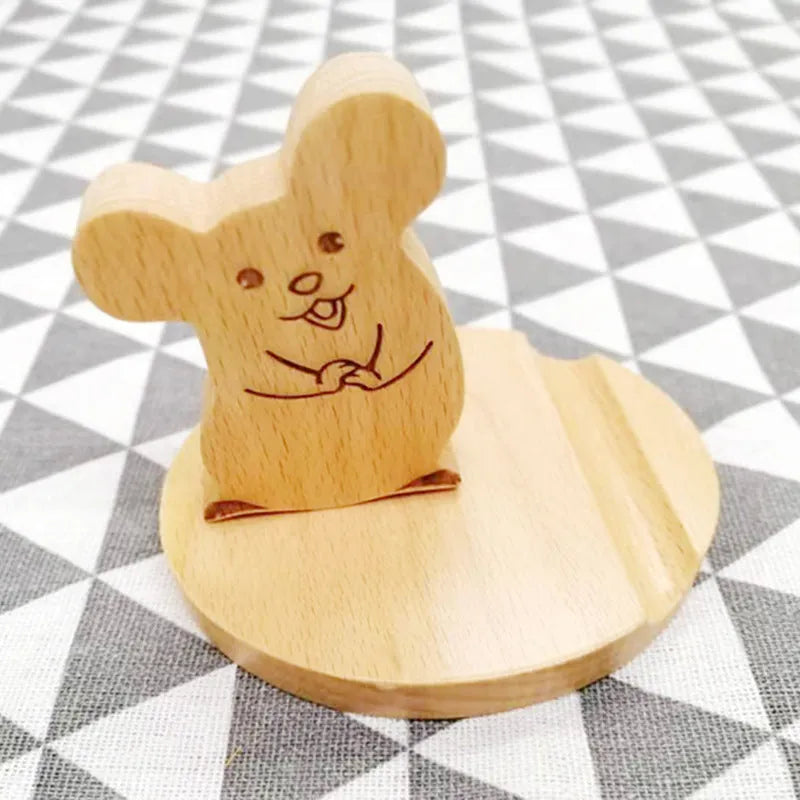 Solid beech wood phone holder with resin puppy decoration and a pound coin in the integrated slot.