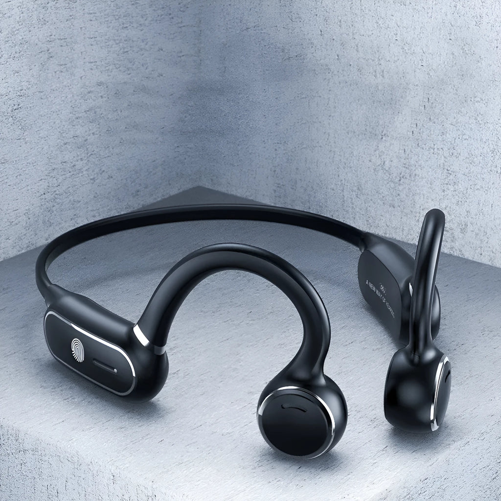 Black air conduction wireless earphone with titanium frame shown bent around a pair of glasses.