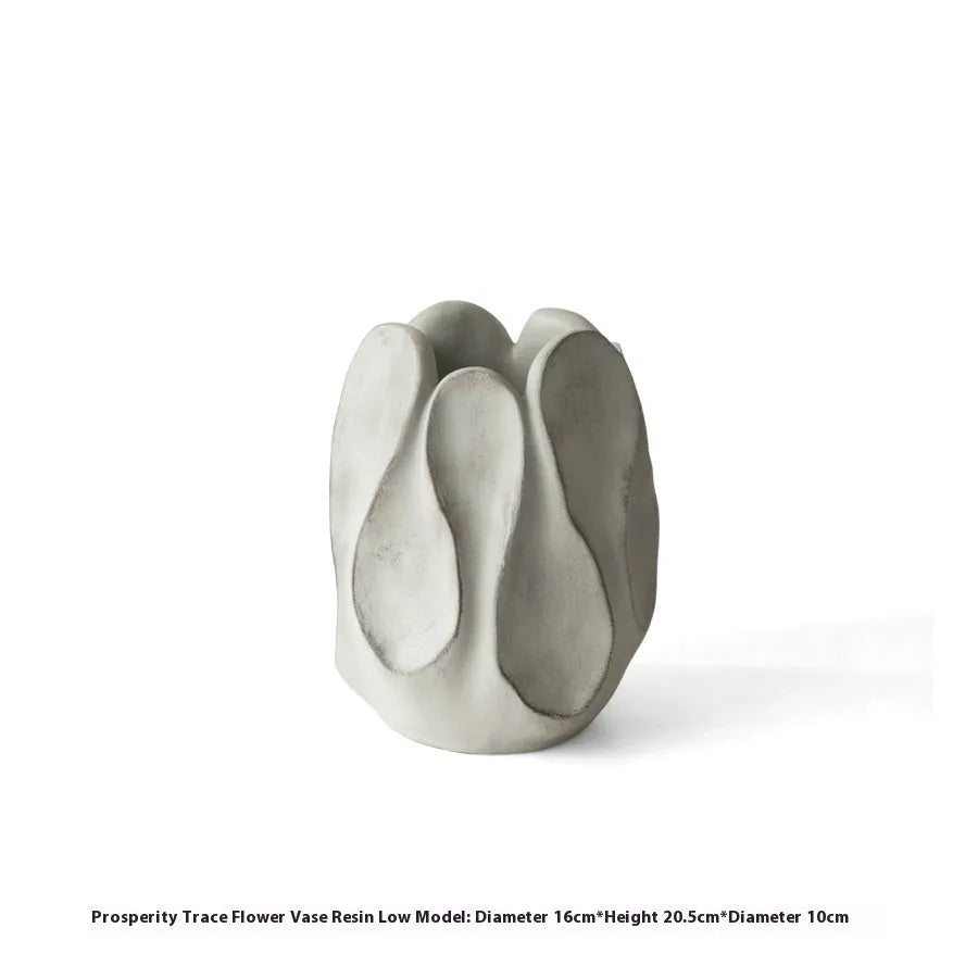 Irregular shaped handcrafted ceramic vase on a wooden surface, showing its artisanal form.