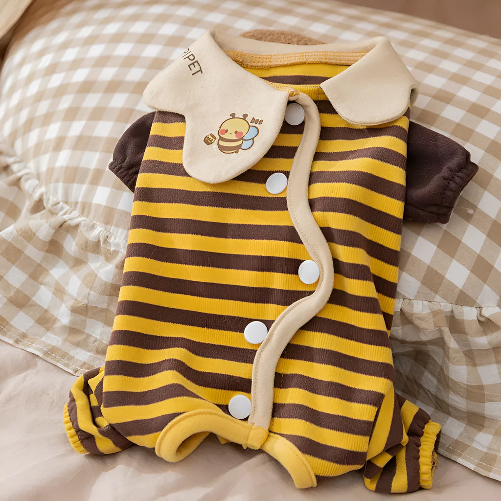 Yellow dog pajamas with bee pattern and lapel on small dog standing indoors