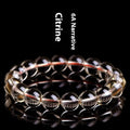 Natural golden citrine bead bracelet with scattered design on a wrist, showing adjustable clasp and polished stone detail.