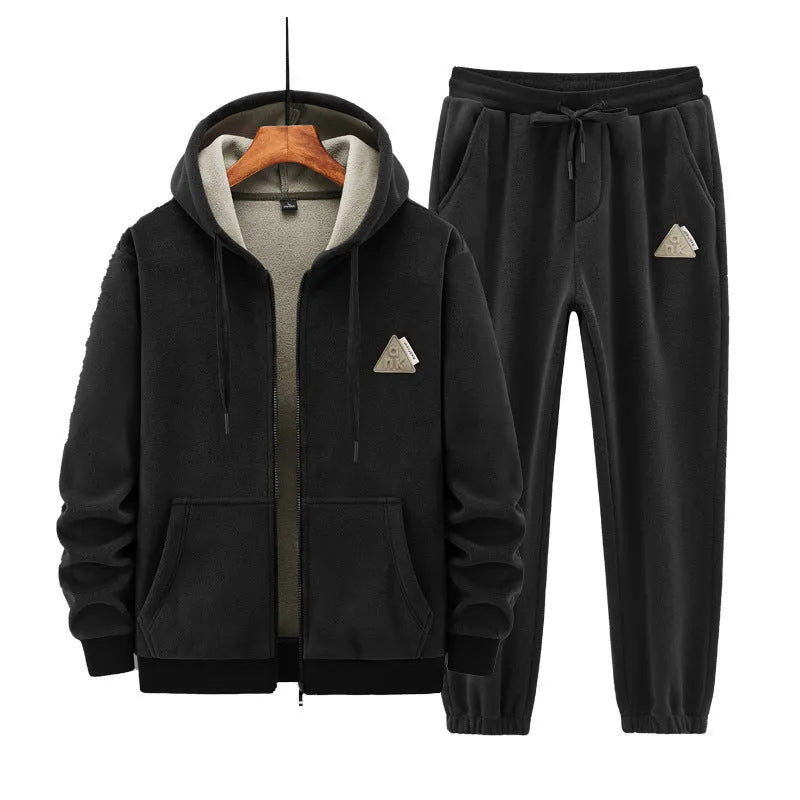 Man wearing a grey hooded sweater and matching casual trousers from a two-piece set.