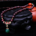 Natural red garnet 7mm bracelet with a golden toad charm on wrist, showing double ring clasp.