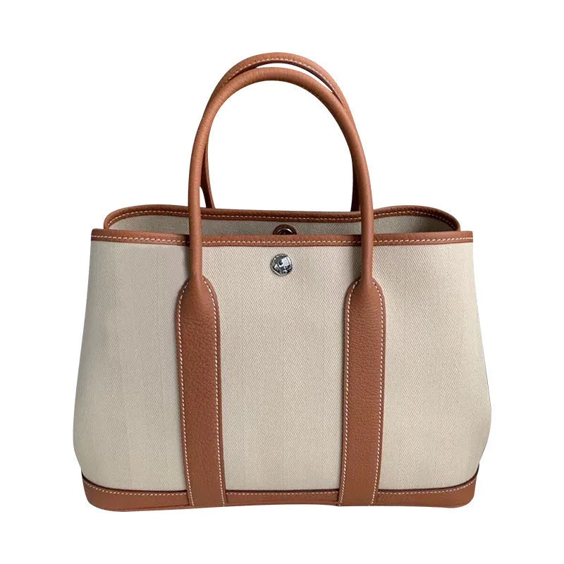 Genuine leather and canvas women's crossbody tote bag in bucket style with soft handle.