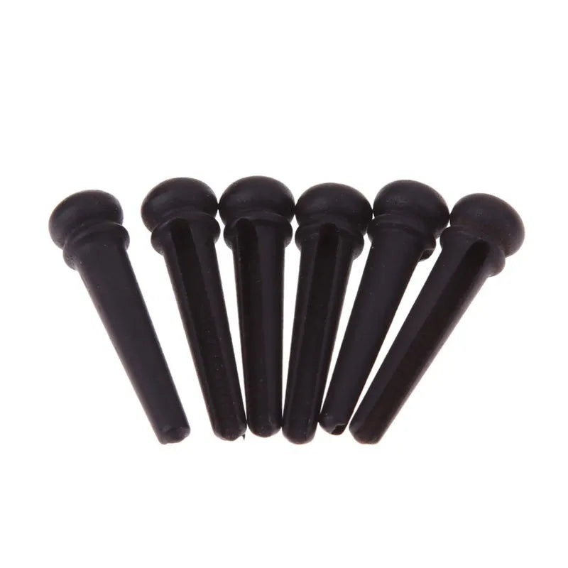 Six matt black ebony wood guitar string nails for folk acoustic guitars.