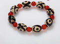 Three-eyed dzi bead bracelet with 10 barrel dzi beads and 6mm red agate beads, 6 inch
