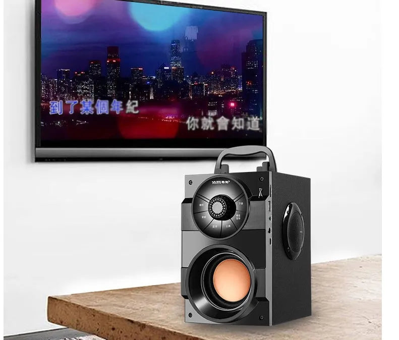 Black portable mini audio system with subwoofer and a 1.2m connection cable on a desk.