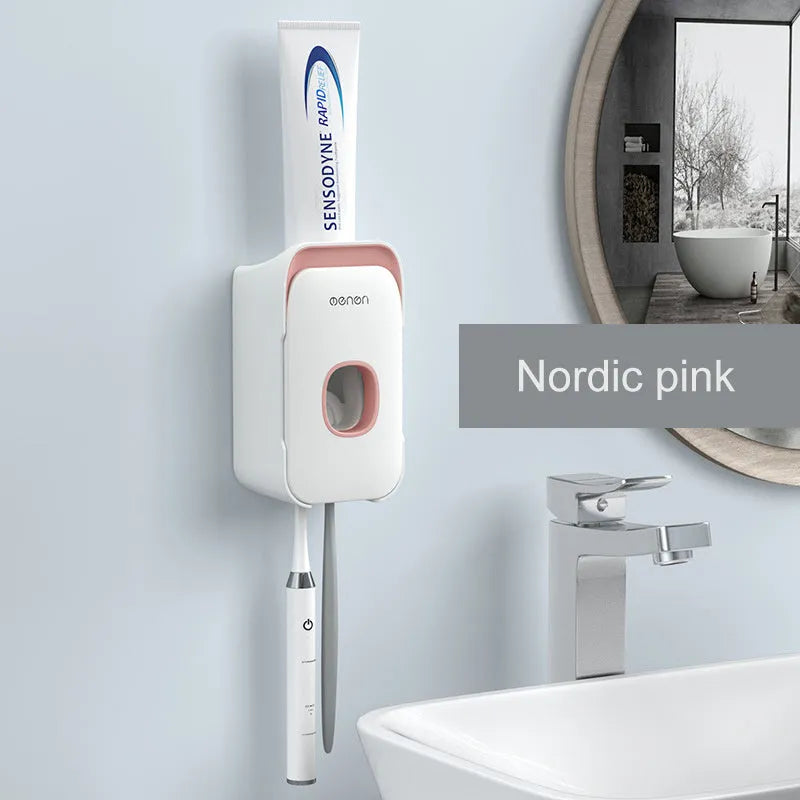 Automatic toothpaste dispenser in grey, blue, and pink colours on a bathroom countertop.