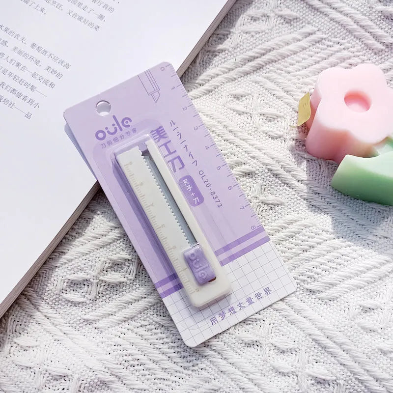 Small plastic-blade art knife in blue, pink, purple, orange, and khaki colours.