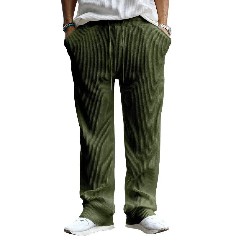 Man wearing loose high-waisted straight-leg casual trousers in army green.