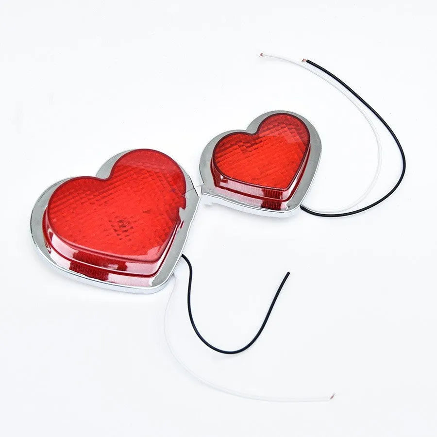 Heart-shaped red LED car fender sidelight on a black background.