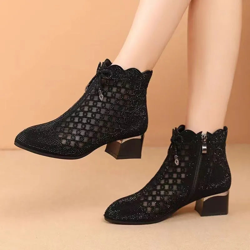 Black women's ankle boots with cutout mesh panels, mid heel, side zipper, and rhinestone sequin details