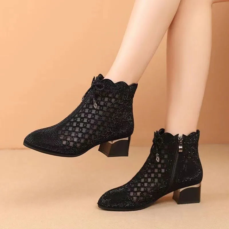 Black women's ankle boots with cutout mesh panels, mid heel, side zipper, and rhinestone sequin details