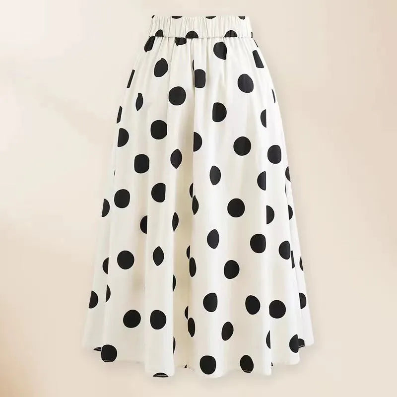 Black one-piece swimsuit for women with a white bow on a short round skirt, showcasing the beach dress style.