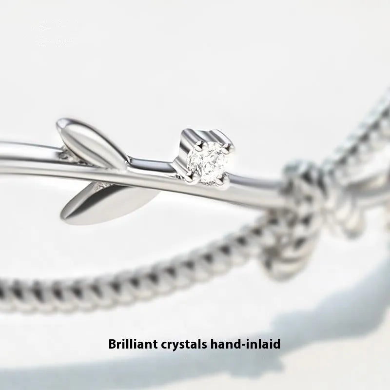 Twisted branch sprout bracelet in white gold finish with detailed copper construction