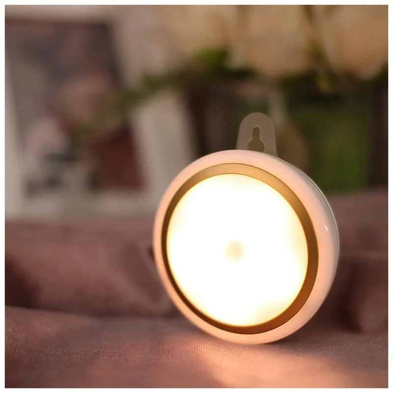 Circular white motion sensor LED light with 80mm diameter, shown mounted inside a wardrobe.
