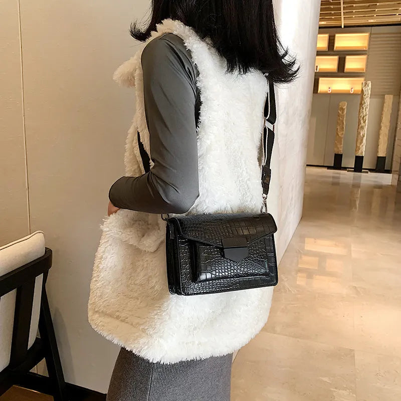 Vintage style black crossbody bag with an adjustable shoulder strap on a mannequin.
