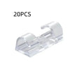 Transparent plastic self-adhesive cable management clips on a white background.