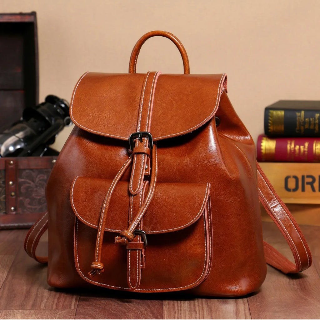 Korean style brown cowhide leather backpack with pull-belt fastening and front sandwich pocket.
