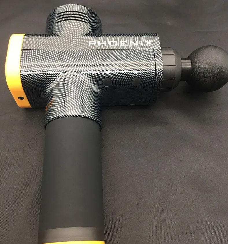 Black ABS fascia massage gun with four different coloured attachment heads on a grey surface.
