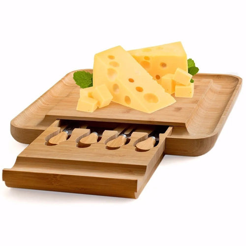 Square bamboo cutting board with drawer holding four-piece knife and fork set in wood colour