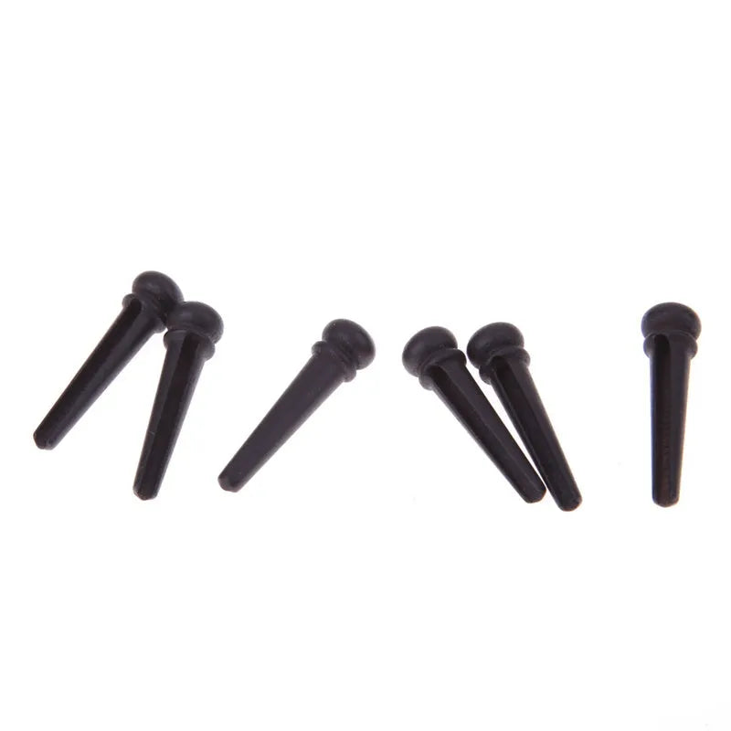 Six matt black ebony wood guitar string nails for folk acoustic guitars.
