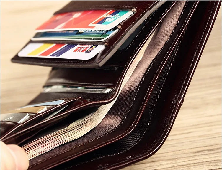 Open view of a black men's leather bifold wallet showing card slots, photo window, and zipped coin pocket.
