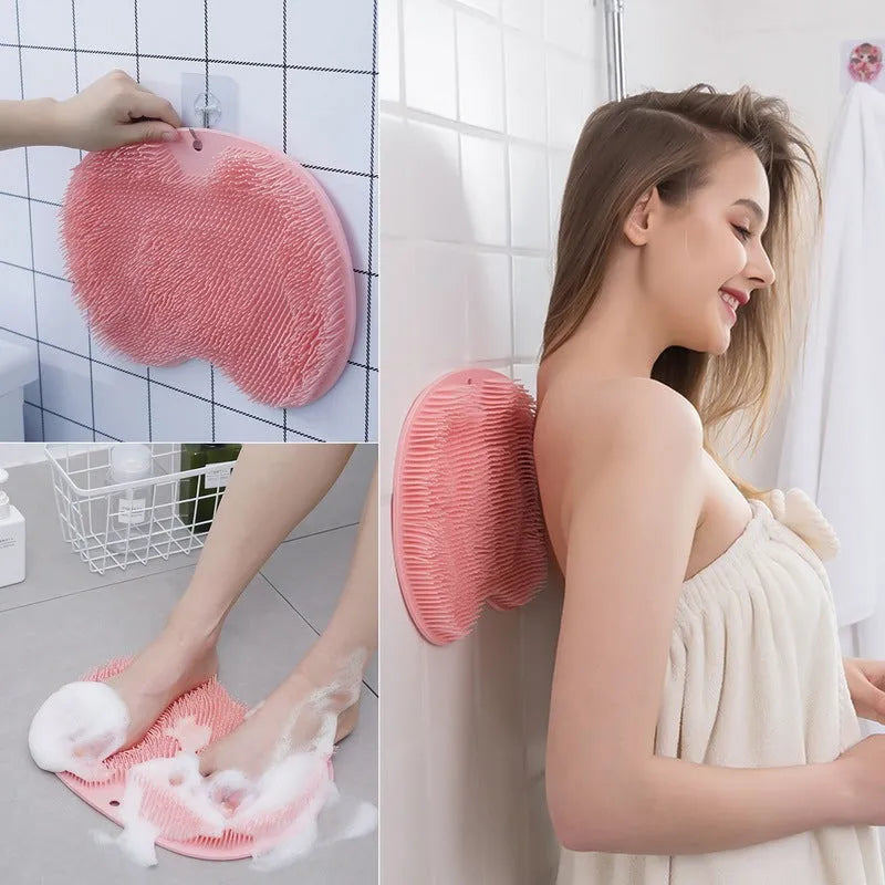 Orange non-slip bath brush with silicone bristles and suction cups on a bathroom floor.