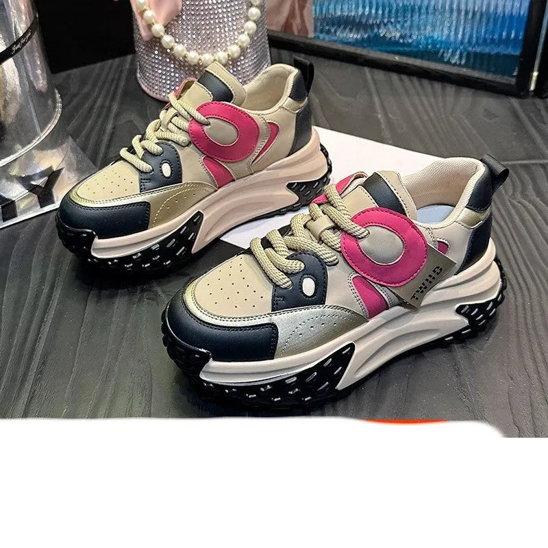 A pair of thick-soled leather casual sports shoes in a black and white colourway with a lace-up front.