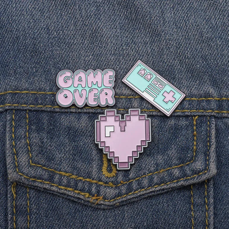 Stereo game console badge made of alloy metal in a three-dimensional design, shown in its OPP packaging.
