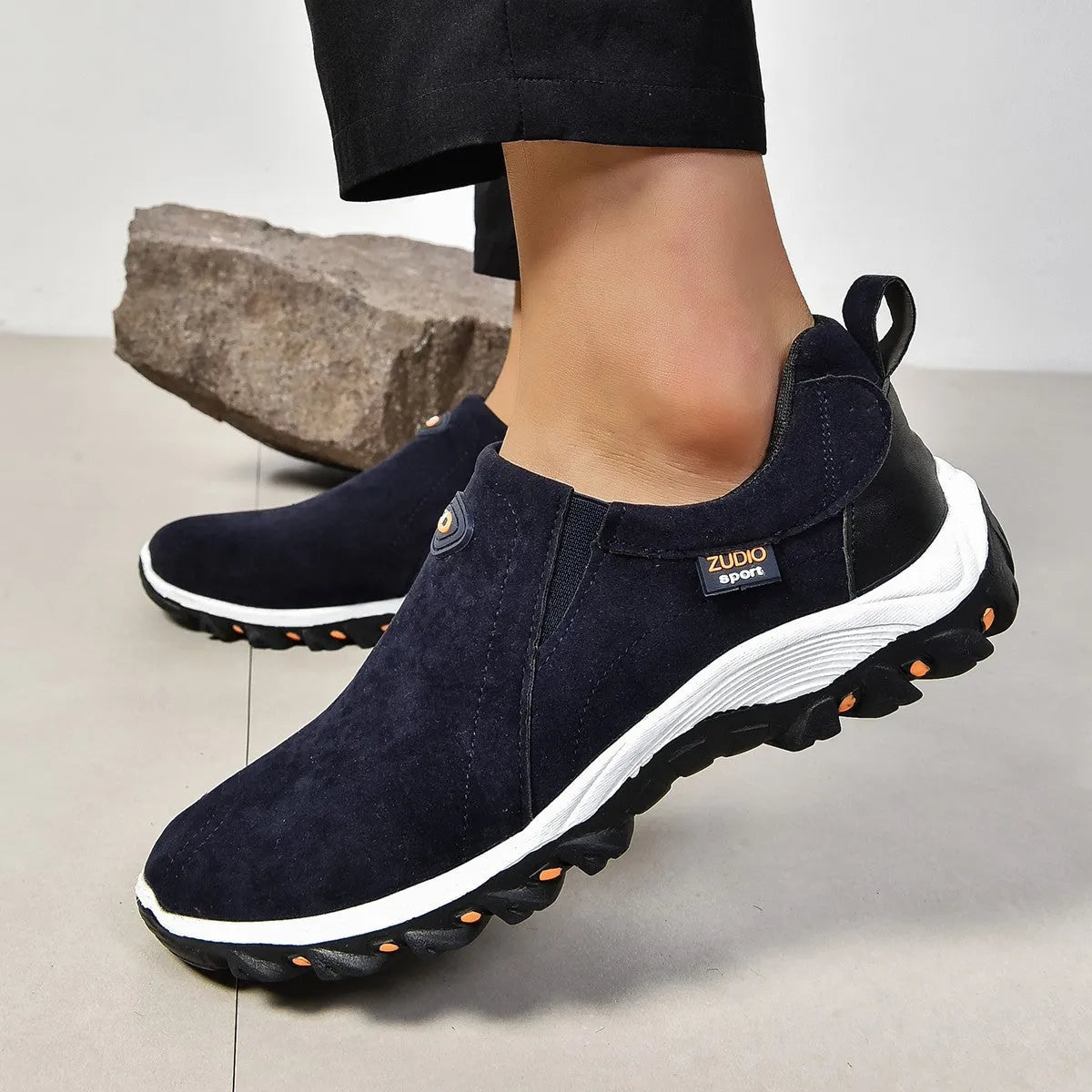 Men's grey slip-on shoe cover with round toe and rubber sole, shown from the side.