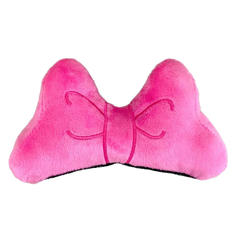 Soft red plush bow tie decoration for helmet customisation, shown against a helmet shell.