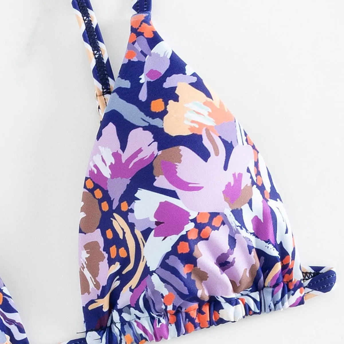 Women's floral print triangle bikini swimsuit with adjustable tie sides on white background
