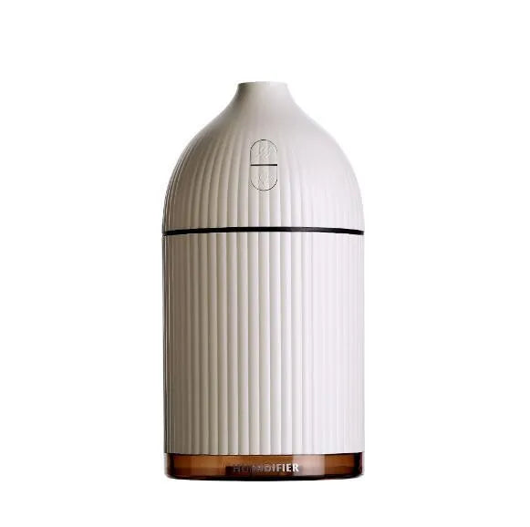 White USB aromatherapy diffuser and humidifier with LED light on a wooden desk