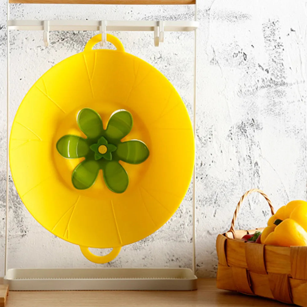 Silicone spill-proof pot cover in black, size 30x26cm, resting on a pot