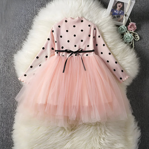 Baby girl wearing a long sleeve black tutu lace dress for a first birthday or christening event.