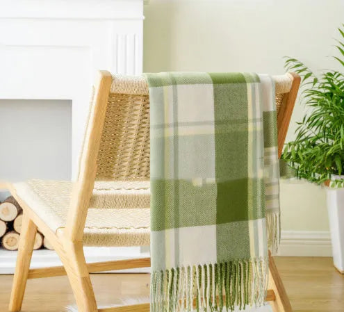 Acrylic chenille plaid throw blanket with tassel trim in gray and white geometric pattern on sofa