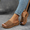 Women's black beach slippers with a flower cutout design on the upper and a wedge-style rubber sole.