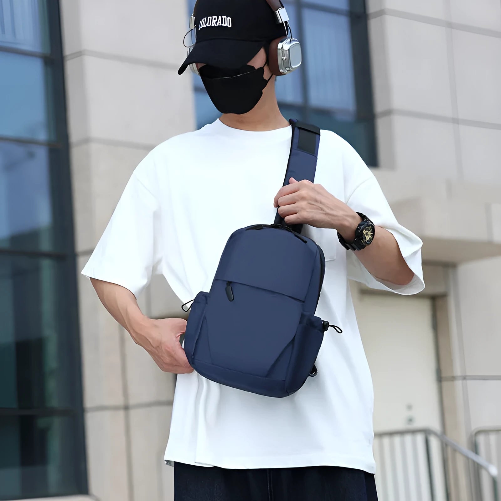 Grey men's chest bag worn across the shoulder, showing main compartment and waterproof-treated fabric.