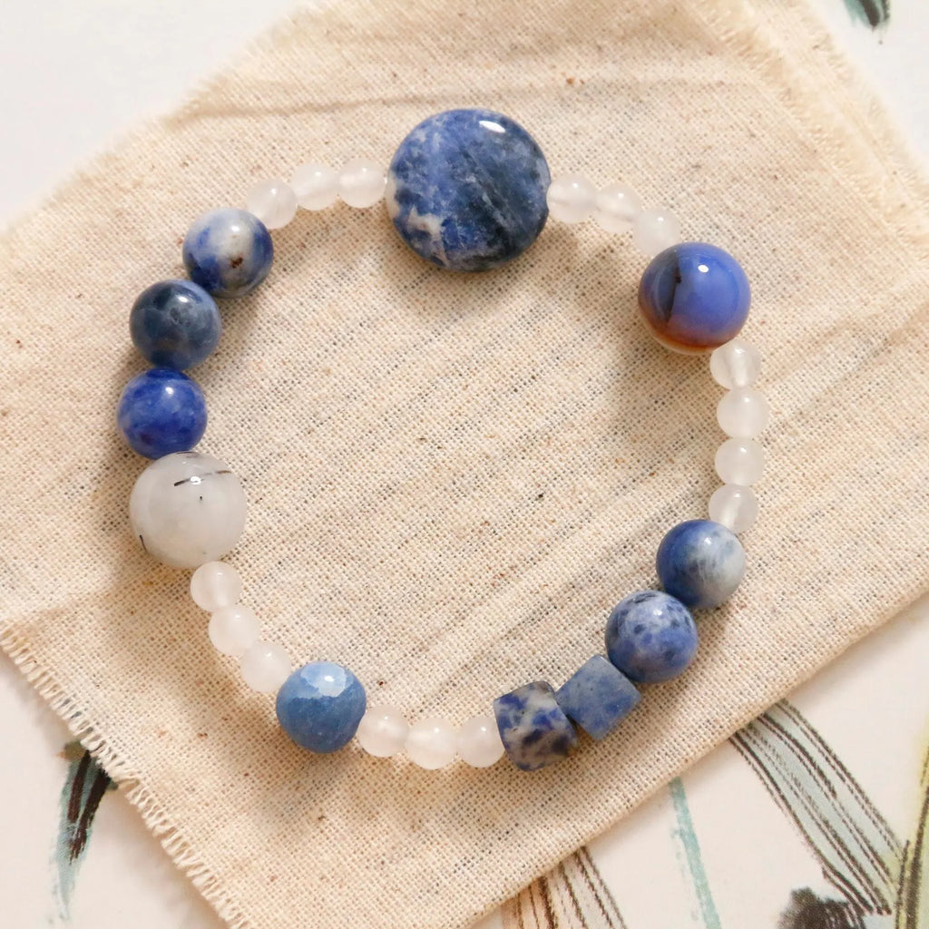 Hand-woven unisex bracelet with blue point stone and black hair crystal agate in a geometric design.