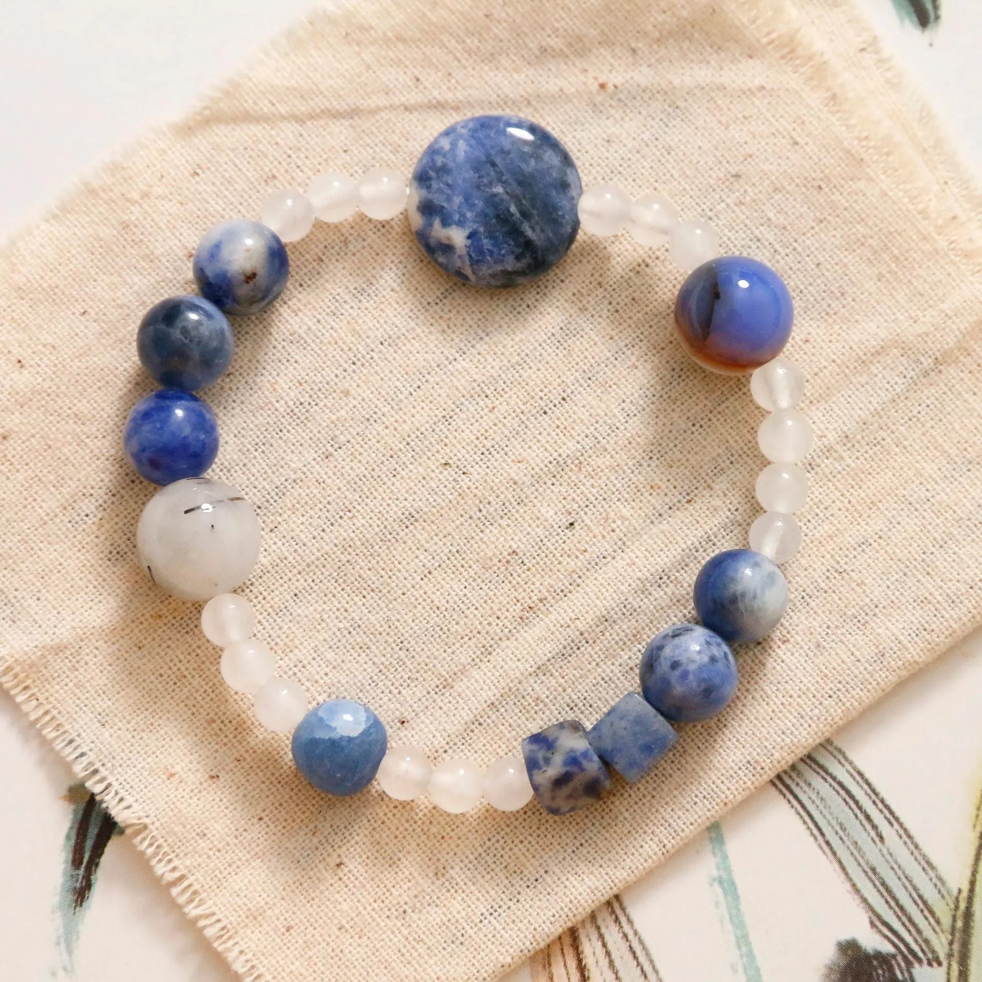 Hand-woven unisex bracelet with blue point stone and black hair crystal agate in a geometric design.