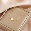 Miniature cross pendant necklace for women in alloy, dainty style on display