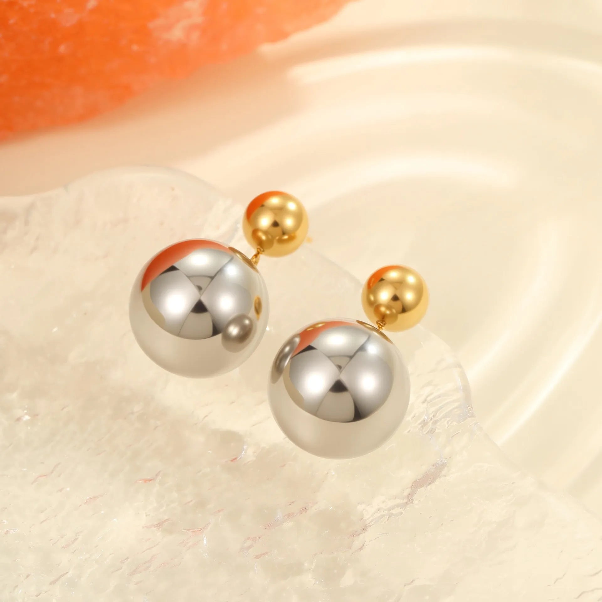 A pair of round bead geometric ear studs with a colour-block electroplated finish on stainless steel.