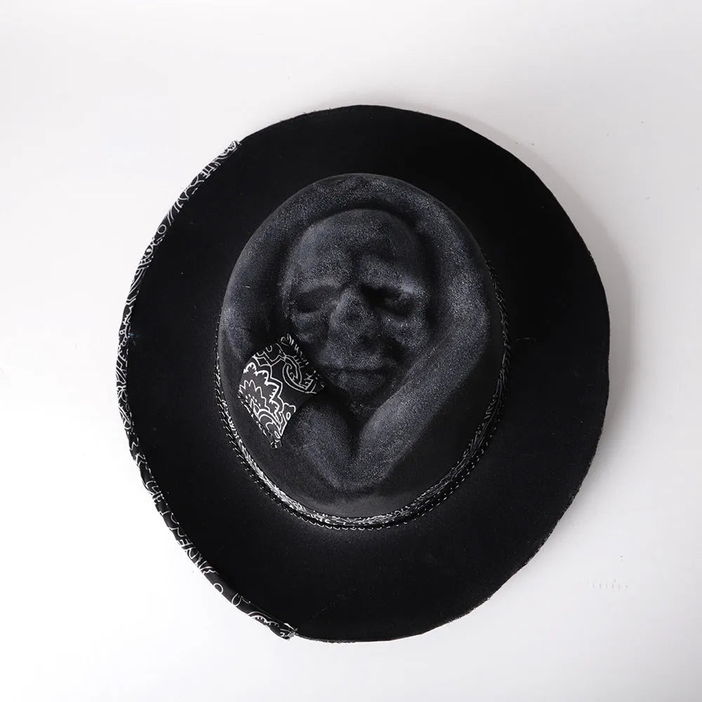 Handmade denim-blue wool felt skull hat with embroidered white skull on front and structured conical crown.